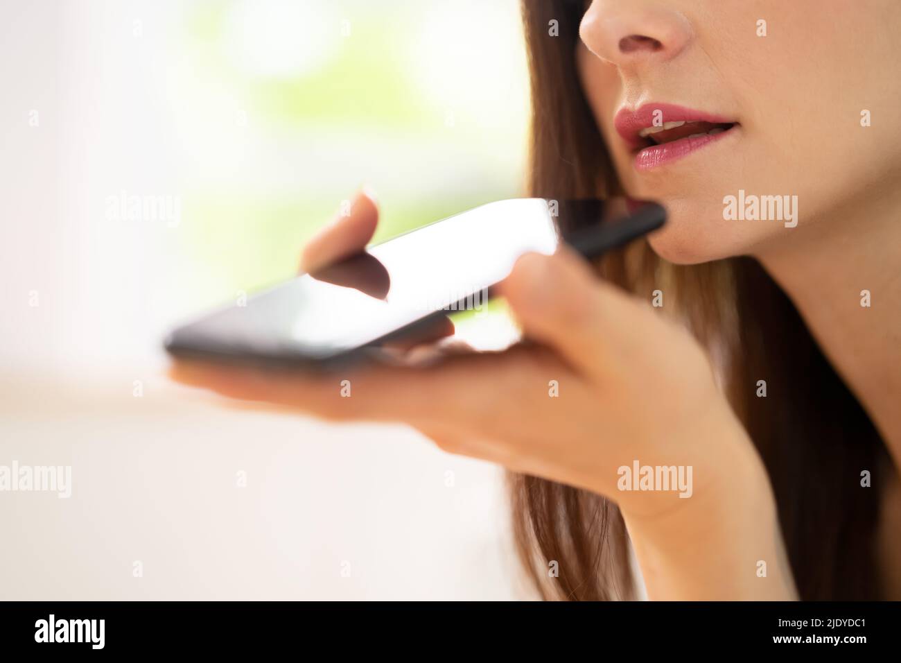 Gros plan d'une femme utilisant Voice Assistant sur un téléphone portable Banque D'Images