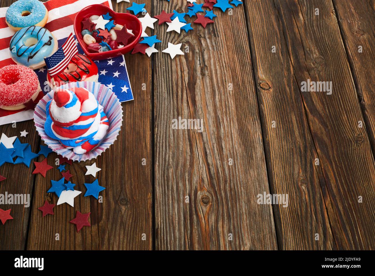 Concept de jour de l'indépendance américaine, de fête et de vacances - beignet glacé, bonbons, petits gâteaux en vaisselle jetable et étoiles. Banque D'Images