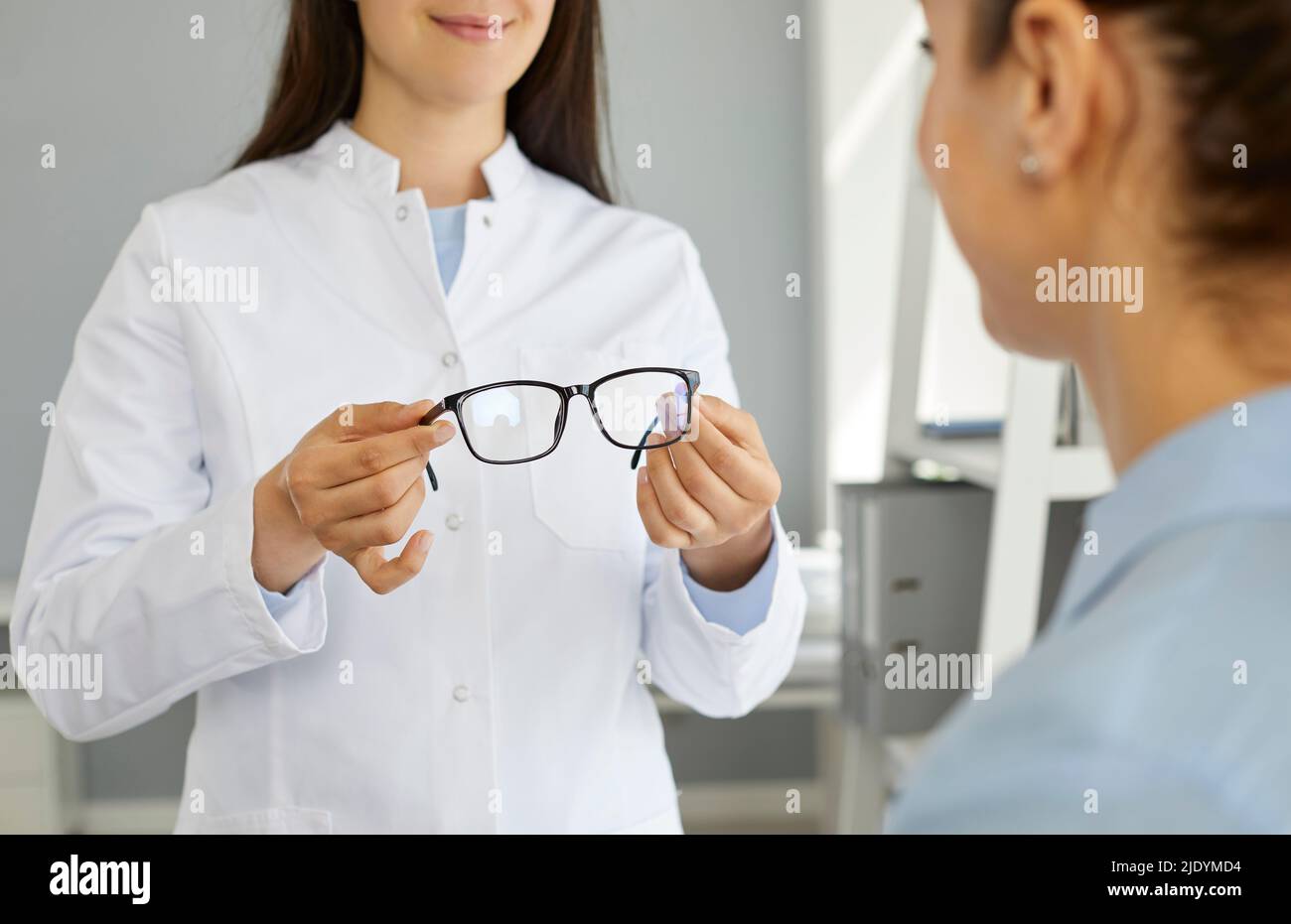 Femme oculiste ou médecin ophtalmologiste au pelage blanc tient des lunettes à la vue du patient Banque D'Images