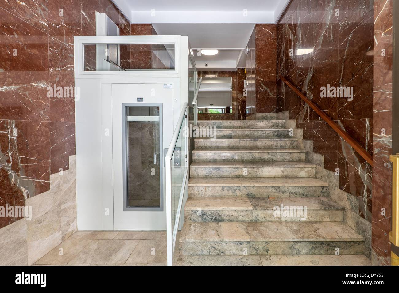 Portail d'un bâtiment avec des escaliers en marbre et un ascenseur hydraulique pour les personnes âgées et les personnes à mobilité réduite Banque D'Images