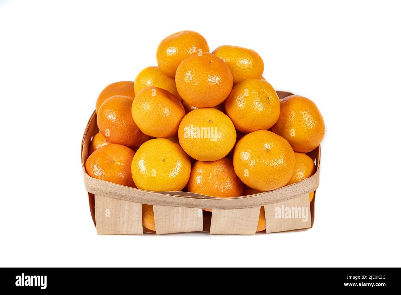 Petite boîte en bois avec pile de mandarines riches et savoureuses isolées sur fond blanc. Banque D'Images