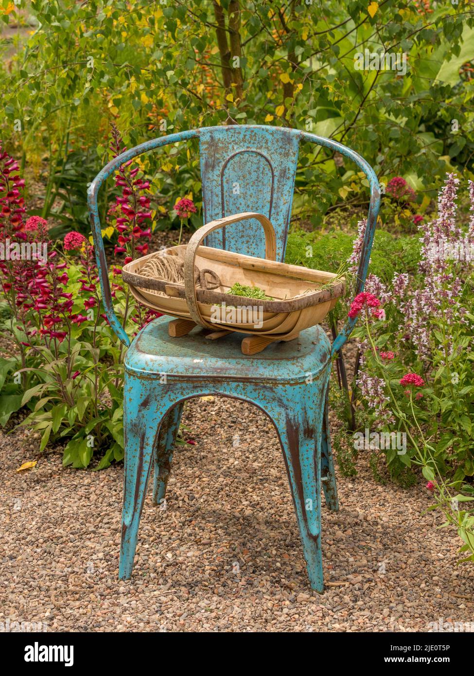 Chaise en métal bleu et tapis de jardin traditionnel dans un jardin d'exposition au Gardeners' World Live. NON CLASSÉ Birmingham Banque D'Images