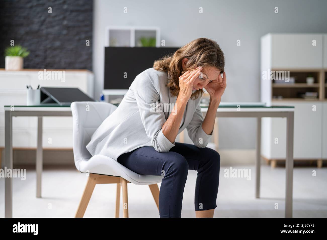 Femme malade stressée à l'ordinateur avec mal de tête Banque D'Images