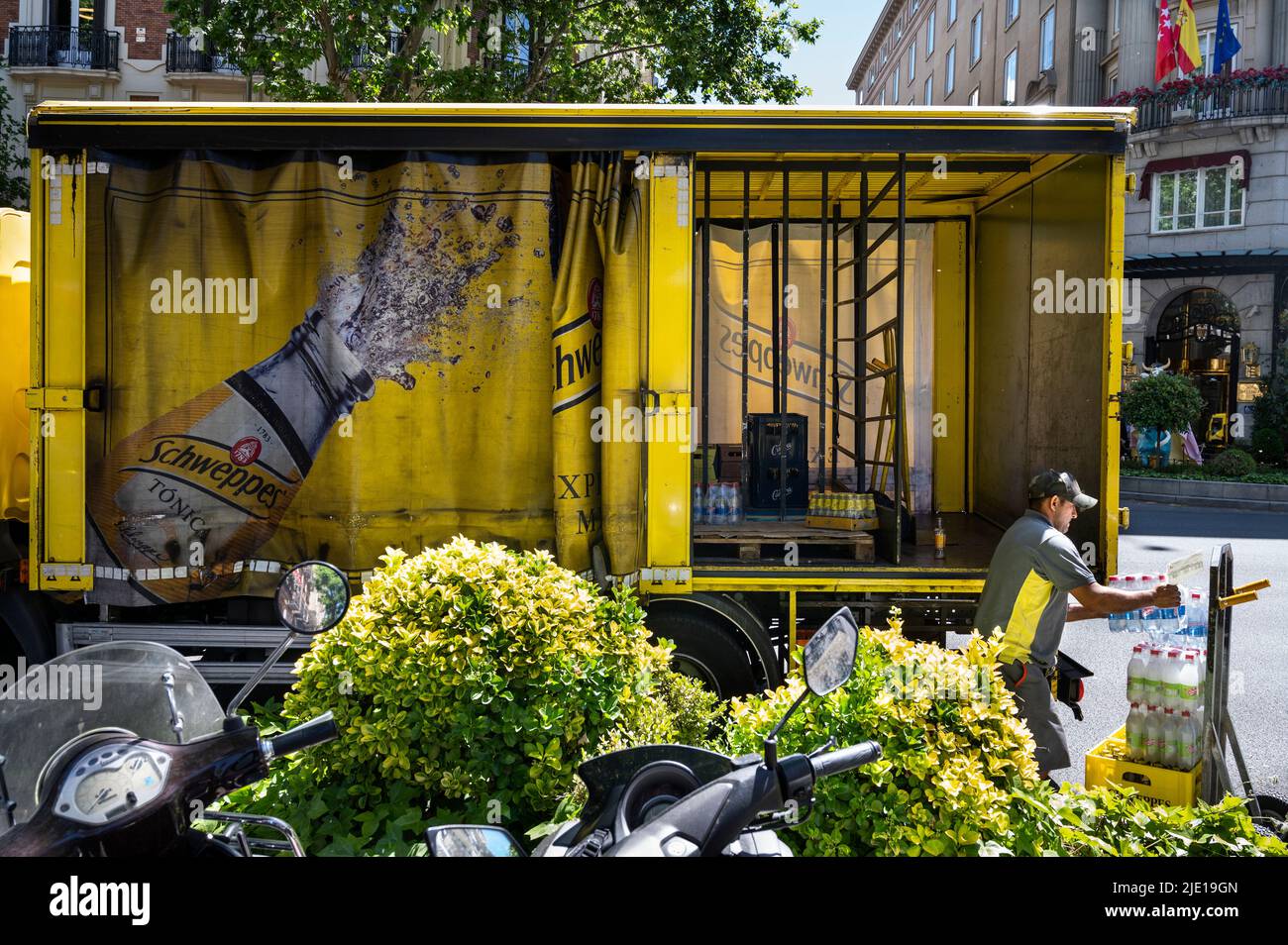 Un employé de camion de livraison déleste la marque suisse de boissons Schweppes en Espagne. Banque D'Images