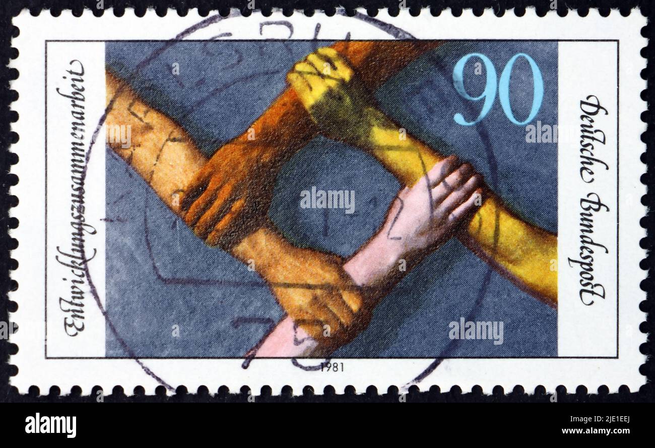 ALLEMAGNE - VERS 1983: Un timbre imprimé en Allemagne montre des armes de différentes races formant la place, la coopération dans le développement du tiers monde, vers 1983 Banque D'Images