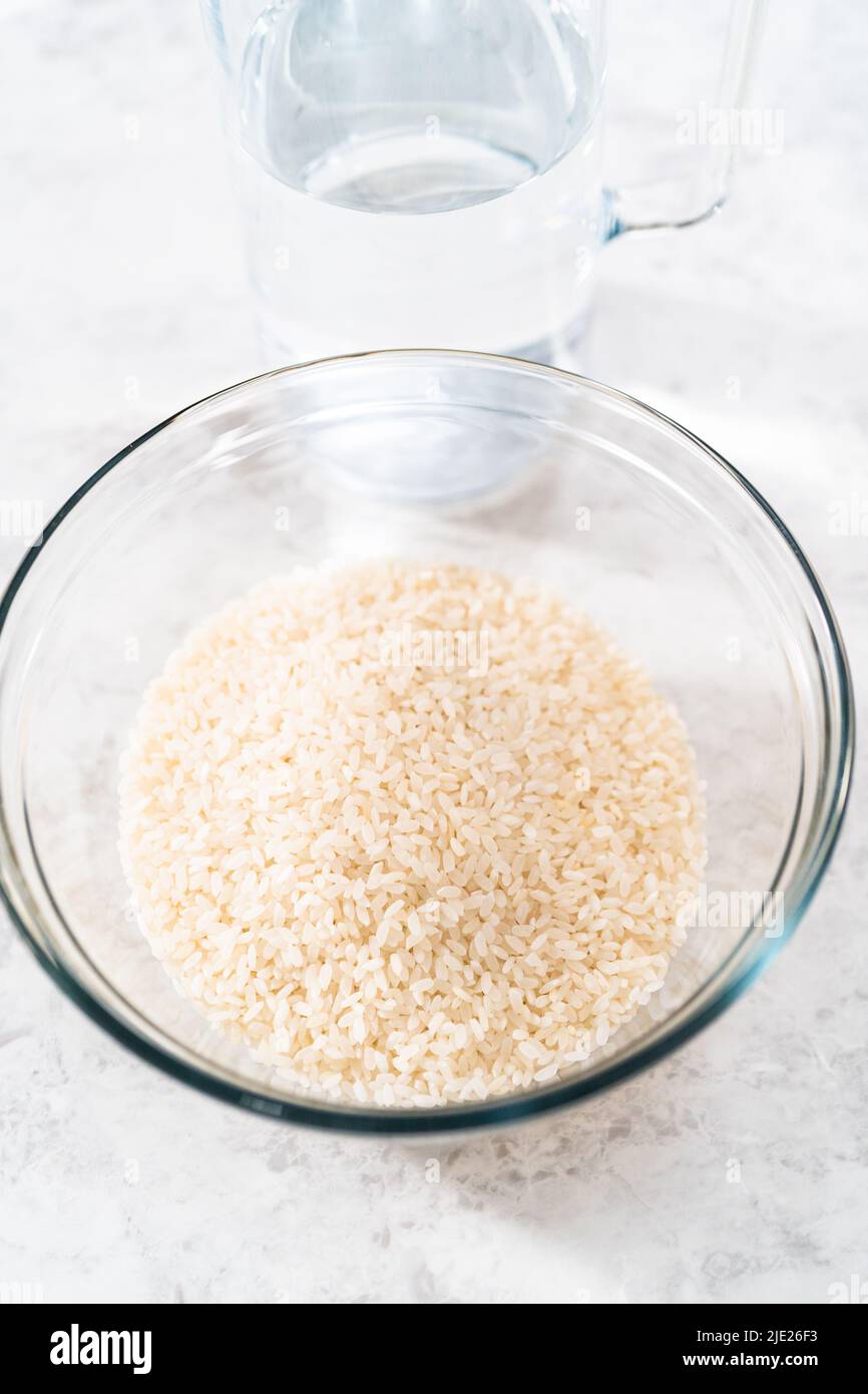 Ingrédients mesurés dans des bols à mélanger en verre pour préparer le riz. Banque D'Images Ingrédients mesurés dans des bols à mélanger en verre pour préparer le riz. Banque D'Images