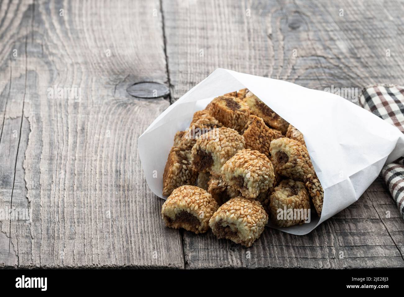 Biscuits arabes Maamoul farcis avec des dates dans un sac en papier sur table en bois Banque D'Images