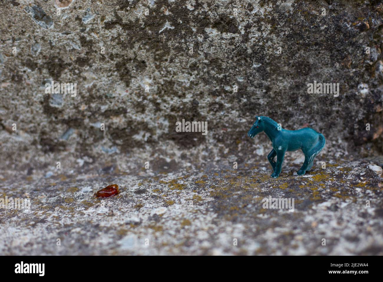 Petite figurine d'un cheval bleu sur fond de pierre grise. Espace de copie. Banque D'Images