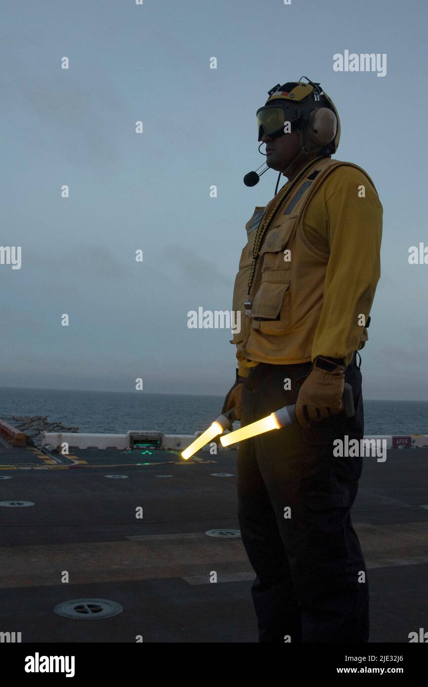 220623-N-XN177-2163 OCÉAN PACIFIQUE (23 juin 2022) – compagnon de bateau d'aviation (manutention) 1st classe Juan Deltoro, de Chicago, se prépare aux opérations de vol de nuit à bord du transporteur d'assaut amphibie USS Tripoli (LHA 7), 23 juin 2022. Tripoli opère dans la zone d'opérations de la flotte américaine 7th afin d'améliorer l'interopérabilité avec ses alliés et ses partenaires et de servir de force de réaction prête à l'emploi pour défendre la paix et maintenir la stabilité dans la région Indo-Pacifique. (É.-U. Photo de la marine par le spécialiste des communications de masse 1st classe Peter Burghart) Banque D'Images