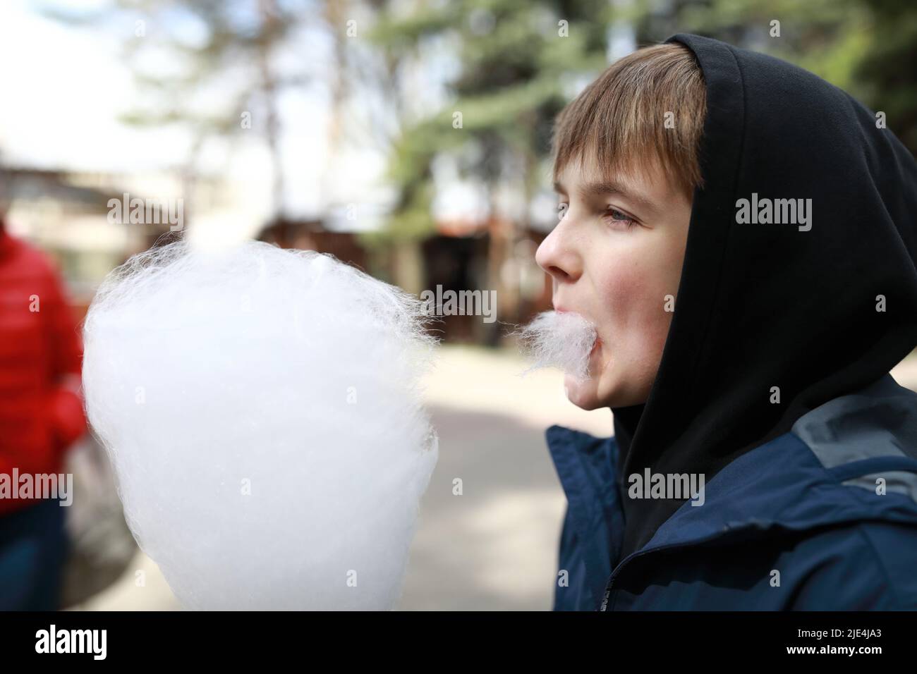 Garçon mangeant des bonbons en coton dans Spring Park Banque D'Images
