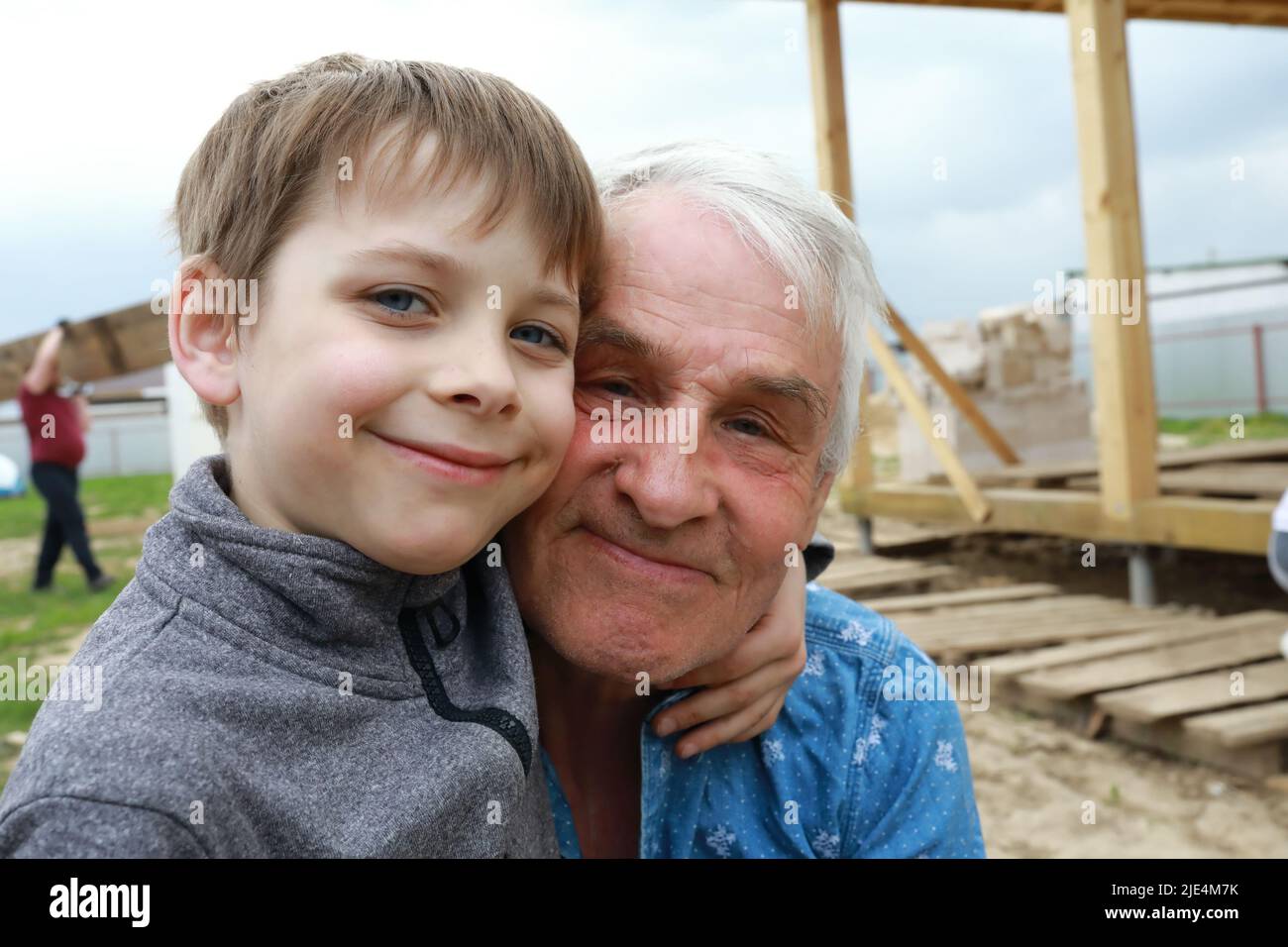 Petit-fils embrassant son grand-père dans l'arrière-cour Banque D'Images