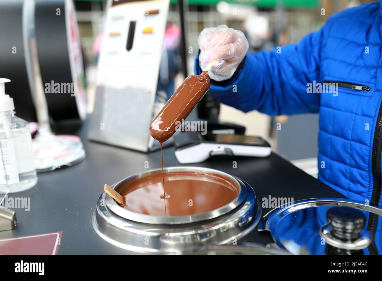 Femme qui bite de la glace au chocolat dans un café Banque D'Images