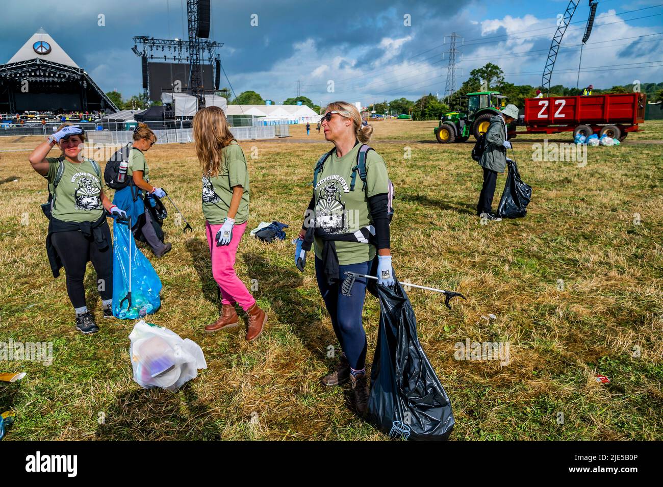 Pilton, Royaume-Uni. 25th juin 2022. Des milliers de bénévoles (beaucoup de collecte d'argent pour les organismes de bienfaisance) nettoient les déchets laissés par les festivaliers la nuit précédente (dans ce cas à l'étape Pyramid). Le travail est nécessaire en dépit de la devise du festival pour «ne laisser aucune trace» - le Glastonbury Festival 50th 2022, digne ferme. Glastonbury, Credit: Guy Bell/Alamy Live News Banque D'Images