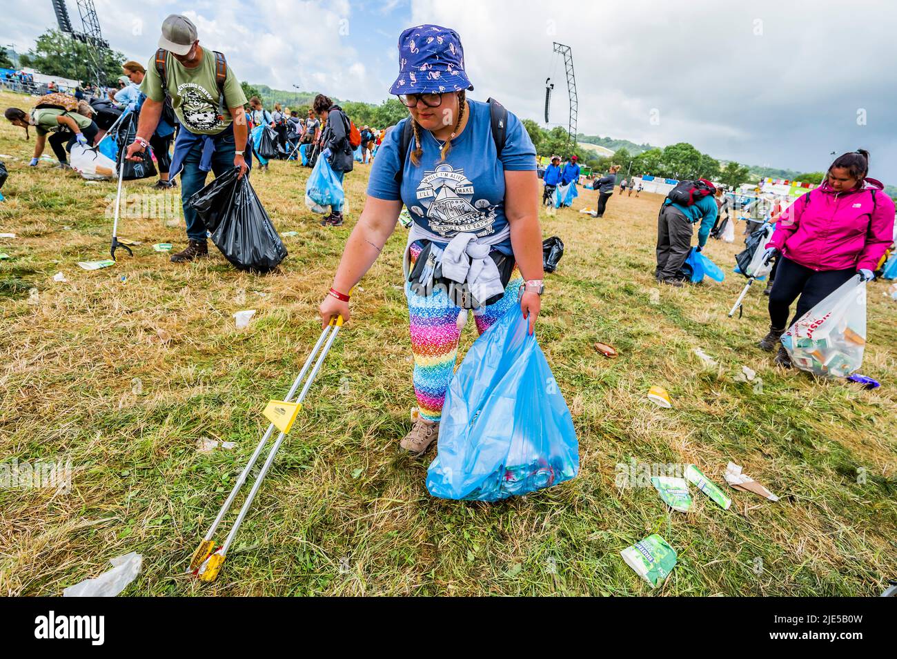 Pilton, Royaume-Uni. 25th juin 2022. Des milliers de bénévoles (beaucoup de collecte d'argent pour les organismes de bienfaisance) nettoient les déchets laissés par les festivaliers la nuit précédente (dans ce cas à l'étape Pyramid). Le travail est nécessaire en dépit de la devise du festival pour «ne laisser aucune trace» - le Glastonbury Festival 50th 2022, digne ferme. Glastonbury, Credit: Guy Bell/Alamy Live News Banque D'Images