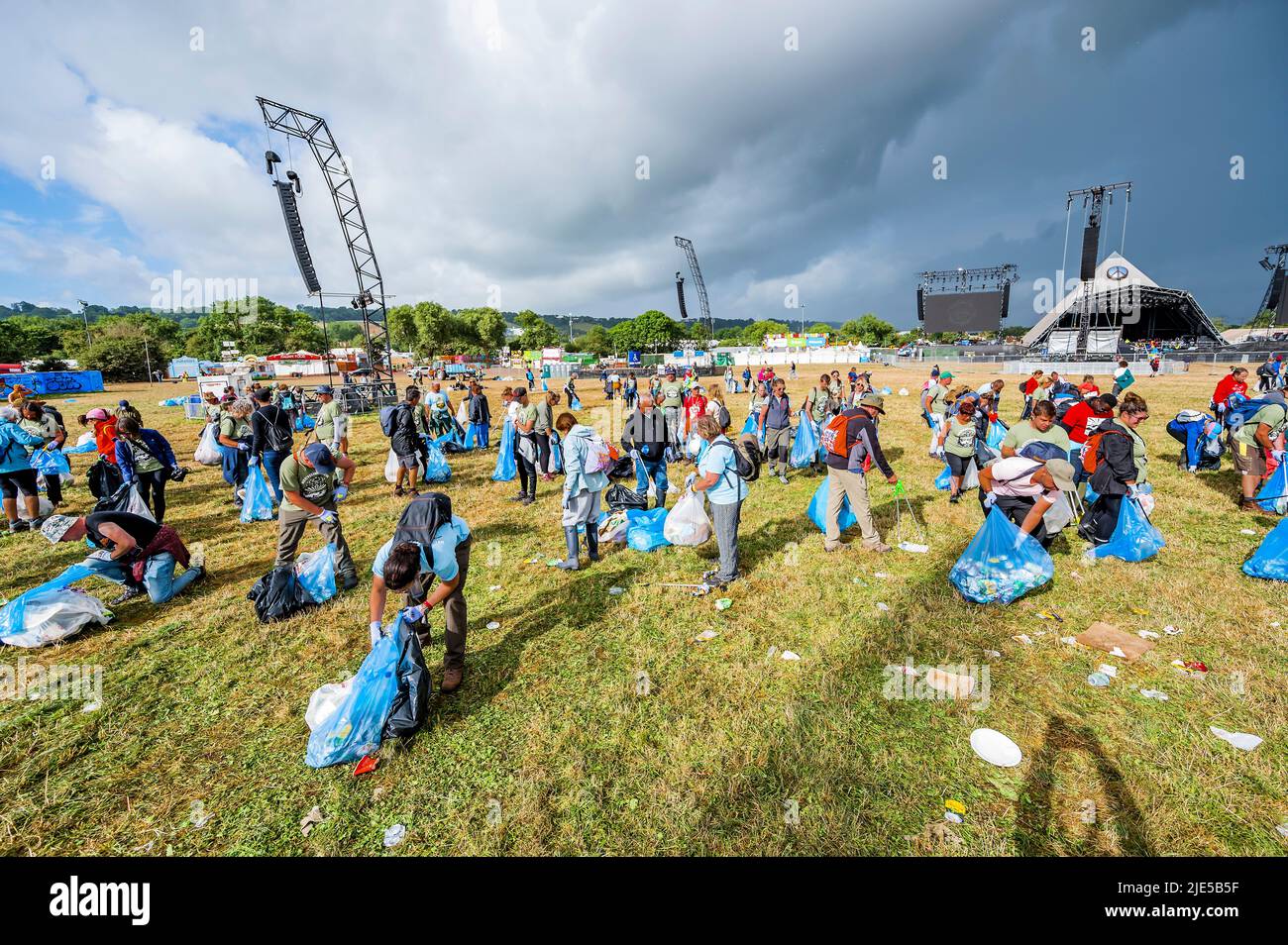 Pilton, Royaume-Uni. 25th juin 2022. Des milliers de bénévoles (beaucoup de collecte d'argent pour les organismes de bienfaisance) nettoient les déchets laissés par les festivaliers la nuit précédente (dans ce cas à l'étape Pyramid). Le travail est nécessaire en dépit de la devise du festival pour «ne laisser aucune trace» - le Glastonbury Festival 50th 2022, digne ferme. Glastonbury, Credit: Guy Bell/Alamy Live News Banque D'Images