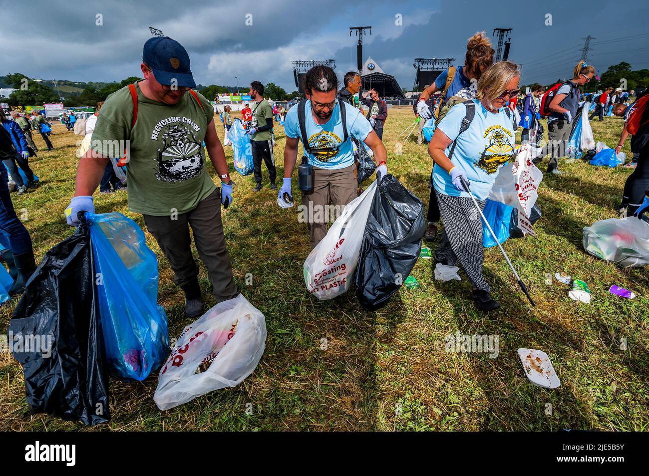 Pilton, Royaume-Uni. 25th juin 2022. Des milliers de bénévoles (beaucoup de collecte d'argent pour les organismes de bienfaisance) nettoient les déchets laissés par les festivaliers la nuit précédente (dans ce cas à l'étape Pyramid). Le travail est nécessaire en dépit de la devise du festival pour «ne laisser aucune trace» - le Glastonbury Festival 50th 2022, digne ferme. Glastonbury, Credit: Guy Bell/Alamy Live News Banque D'Images