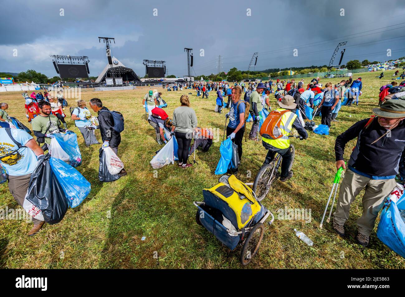 Pilton, Royaume-Uni. 25th juin 2022. Des milliers de bénévoles (beaucoup de collecte d'argent pour les organismes de bienfaisance) nettoient les déchets laissés par les festivaliers la nuit précédente (dans ce cas à l'étape Pyramid). Le travail est nécessaire en dépit de la devise du festival pour «ne laisser aucune trace» - le Glastonbury Festival 50th 2022, digne ferme. Glastonbury, Credit: Guy Bell/Alamy Live News Banque D'Images