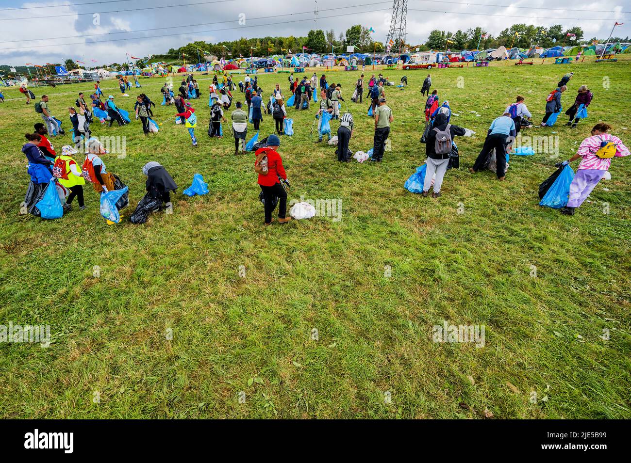 Pilton, Royaume-Uni. 25th juin 2022. Des milliers de bénévoles (beaucoup de collecte d'argent pour les organismes de bienfaisance) nettoient les déchets laissés par les festivaliers la nuit précédente (dans ce cas à l'étape Pyramid). Le travail est nécessaire en dépit de la devise du festival pour «ne laisser aucune trace» - le Glastonbury Festival 50th 2022, digne ferme. Glastonbury, Credit: Guy Bell/Alamy Live News Banque D'Images