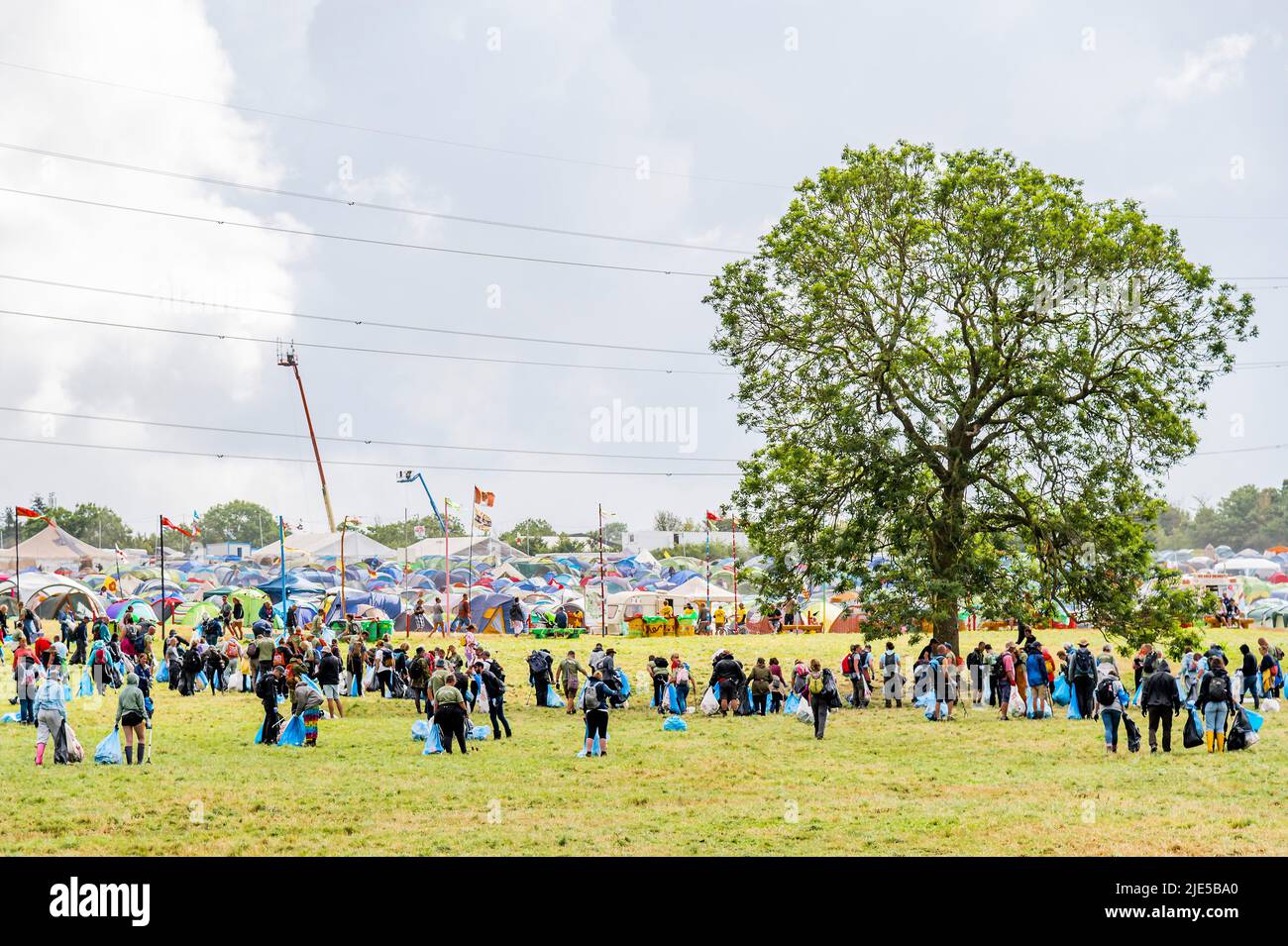 Pilton, Royaume-Uni. 25th juin 2022. Des milliers de bénévoles (beaucoup de collecte d'argent pour les organismes de bienfaisance) nettoient les déchets laissés par les festivaliers la nuit précédente (dans ce cas à l'étape Pyramid). Le travail est nécessaire en dépit de la devise du festival pour «ne laisser aucune trace» - le Glastonbury Festival 50th 2022, digne ferme. Glastonbury, Credit: Guy Bell/Alamy Live News Banque D'Images