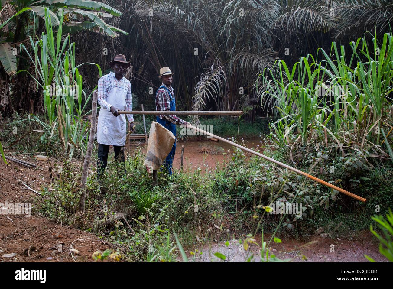 Deux pêcheurs africains pêchent avec des cannes à pêche dans le lac, ouvriers en afrique Banque D'Images