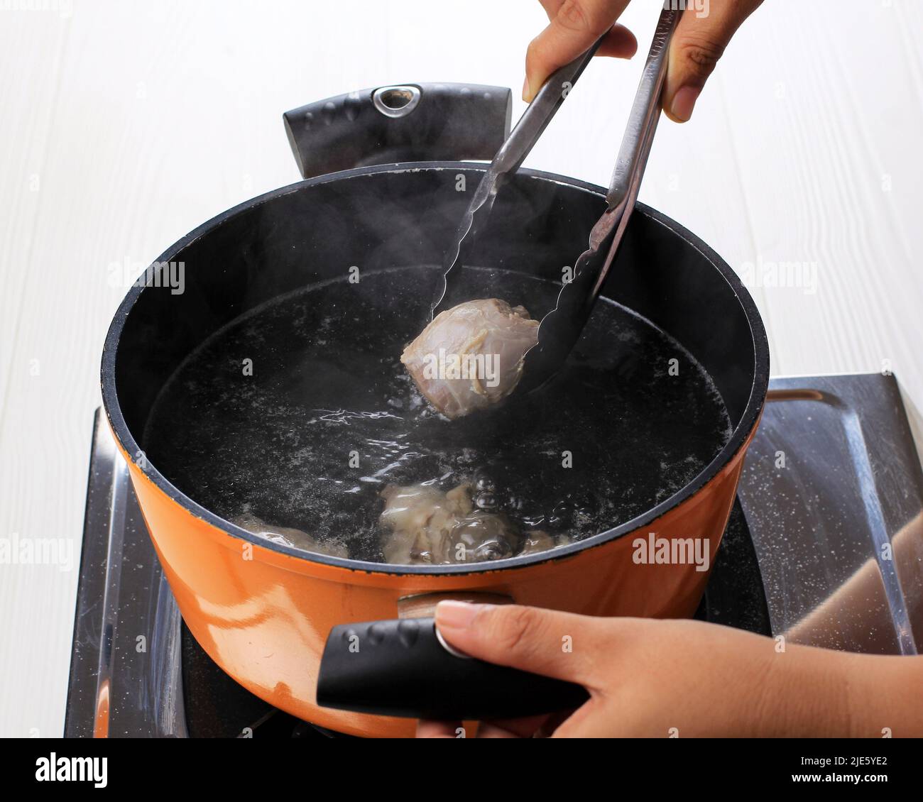 Femme bœuf bouilli à la main sur la poêle, processus de cuisson à la maison Rawon (soupe noire indonésienne) Banque D'Images