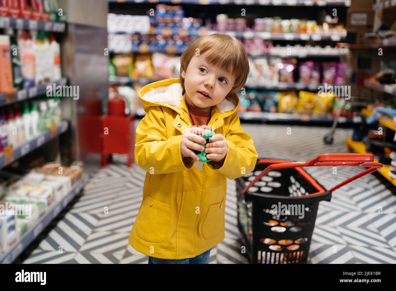 un enfant sur le marché avec un chariot d'épicerie achète une balle Banque D'Images