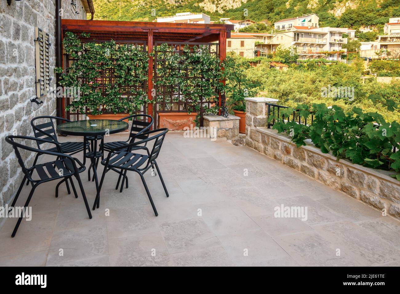 Rijeka Rezevici, Monténégro - 3 juin 2022: Table avec chaises sur la terrasse donnant sur les montagnes et le village de Rijeka Rezevici, Monténégro, Banque D'Images