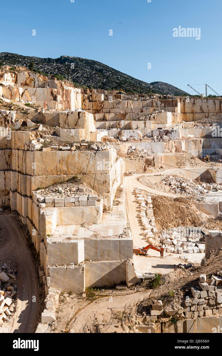 Mur de roche, rampes, blocs et excavateurs dans la carrière de marbre près d'Orosei sur la côte est de la Sardaigne, Baronia, Italie Banque D'Images