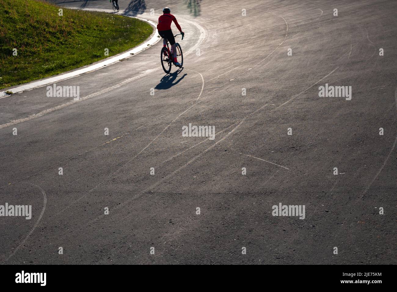 Silhouette d'un entraînement de motard sur la piste de course de vélo dans un parc. Photo de fond de style de vie sain ou d'entraînement ou de sport. Banque D'Images