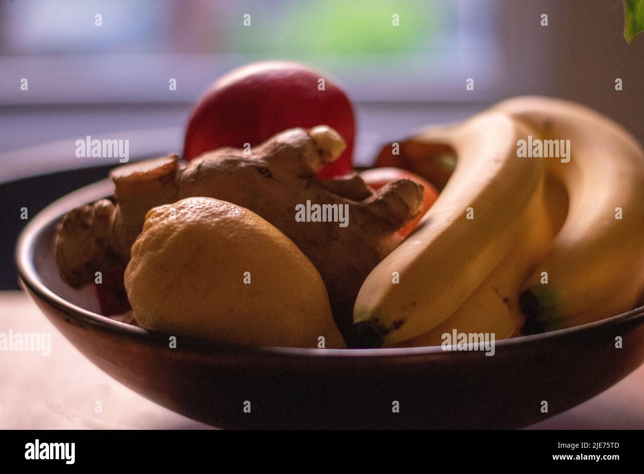 Bol de fruits mélangé sur la table avec des racines de citron et de gingembre Banque D'Images