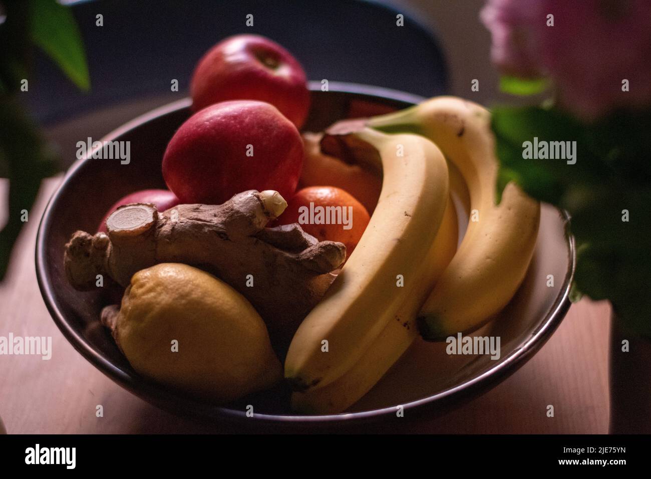 Bol de fruits mélangé sur la table avec des racines de citron et de gingembre Banque D'Images
