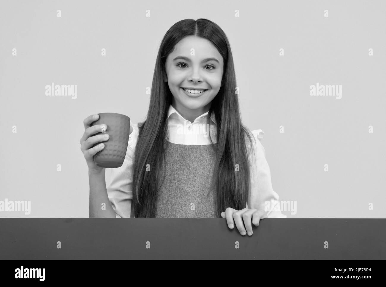 Nouvelle soif, nouvelle boisson.Un enfant heureux tient une tasse en plastique.Obéissez à la soif en vous Banque D'Images