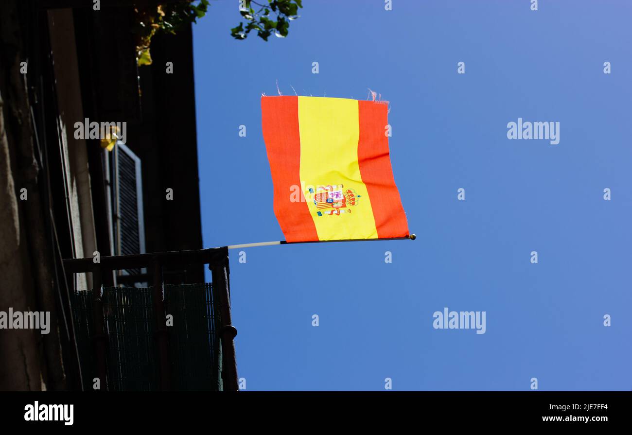 Drapeau espagnol. Le drapeau jaune rouge flotte dans le vent contre le ciel bleu. Un drapeau orne le balcon du bâtiment d'appartement. Un symbole d'indépendance. Nation espagnole Banque D'Images
