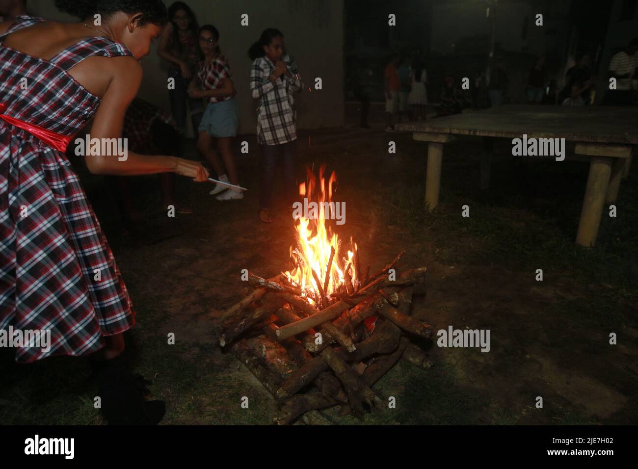 salvador, bahia, brésil - 11 juin 2022 : enfants portant des vêtements typiques de cou rouge à côté d'un feu de joie à la fête de Sao Joao dans la ville de Salvador. Banque D'Images