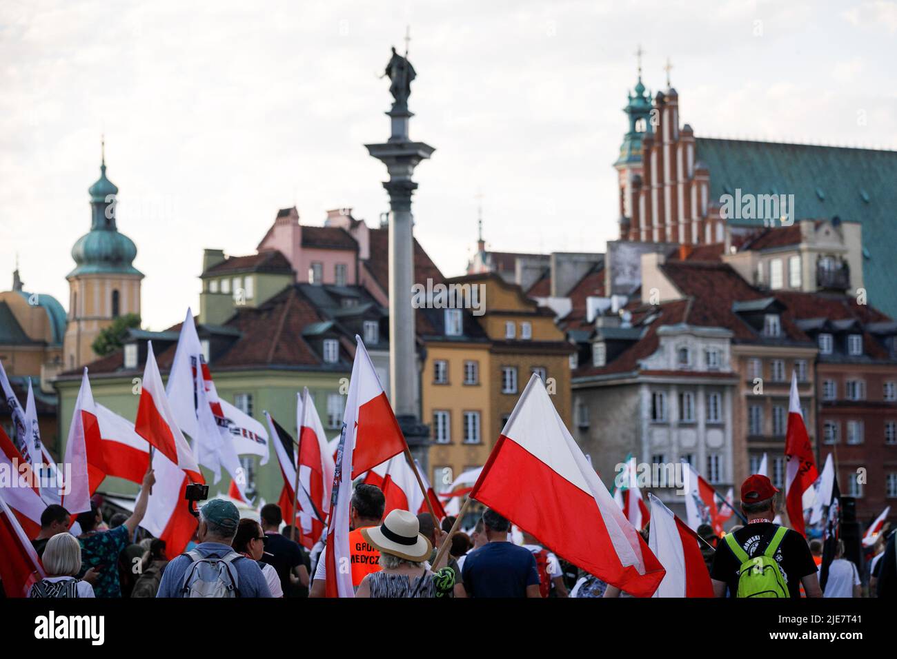 Varsovie, Pologne. 25th juin 2022. Les manifestants tiennent des drapeaux rouges blancs polonais près de la colonne de Sigismund lors de la deuxième marche de Dmowski jusqu'au château. La deuxième marche de Dmowski au château a été organisée par les nationalistes polonais. Roman Dmowski était un politicien polonais, co-fondateur et principal idéologue de la démocratie nationale polonaise. Au cours du mois de mars, les participants avec le drapeau national polonais marchent dans les rues de Varsovie avec le buste de Dmowski. Crédit : SOPA Images Limited/Alamy Live News Banque D'Images