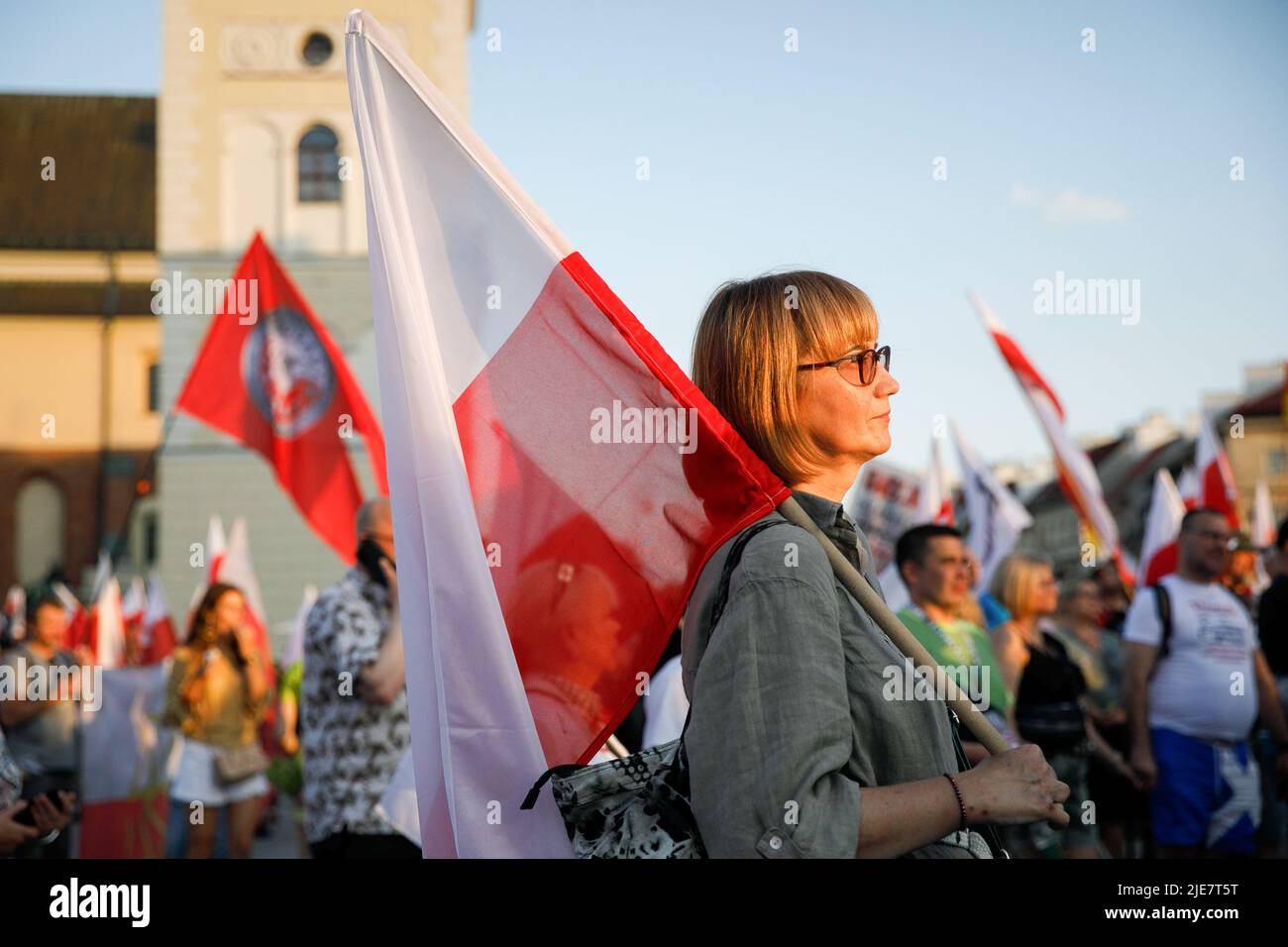 Varsovie, Pologne. 25th juin 2022. Un démonstrateur détient le drapeau rouge-blanc polonais pendant la deuxième marche de Dmowski jusqu'au château. La deuxième marche de Dmowski au château a été organisée par les nationalistes polonais. Roman Dmowski était un politicien polonais, co-fondateur et principal idéologue de la démocratie nationale polonaise. Au cours du mois de mars, les participants avec le drapeau national polonais marchent dans les rues de Varsovie avec le buste de Dmowski. Crédit : SOPA Images Limited/Alamy Live News Banque D'Images