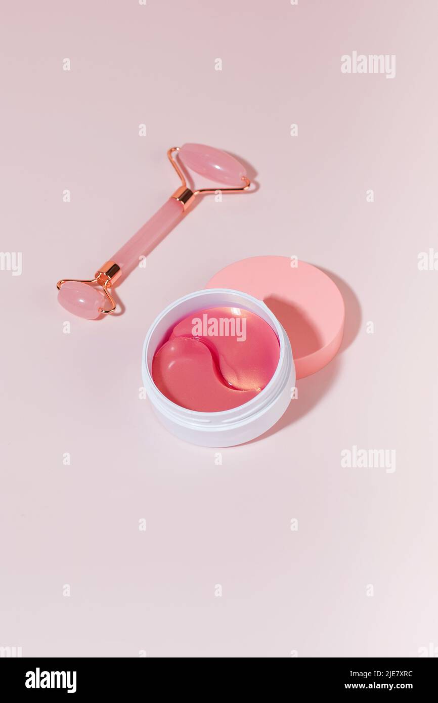 Plaques roses hydrogel, rouleau de quartz sur fond rose avec ombres dures. Banque D'Images