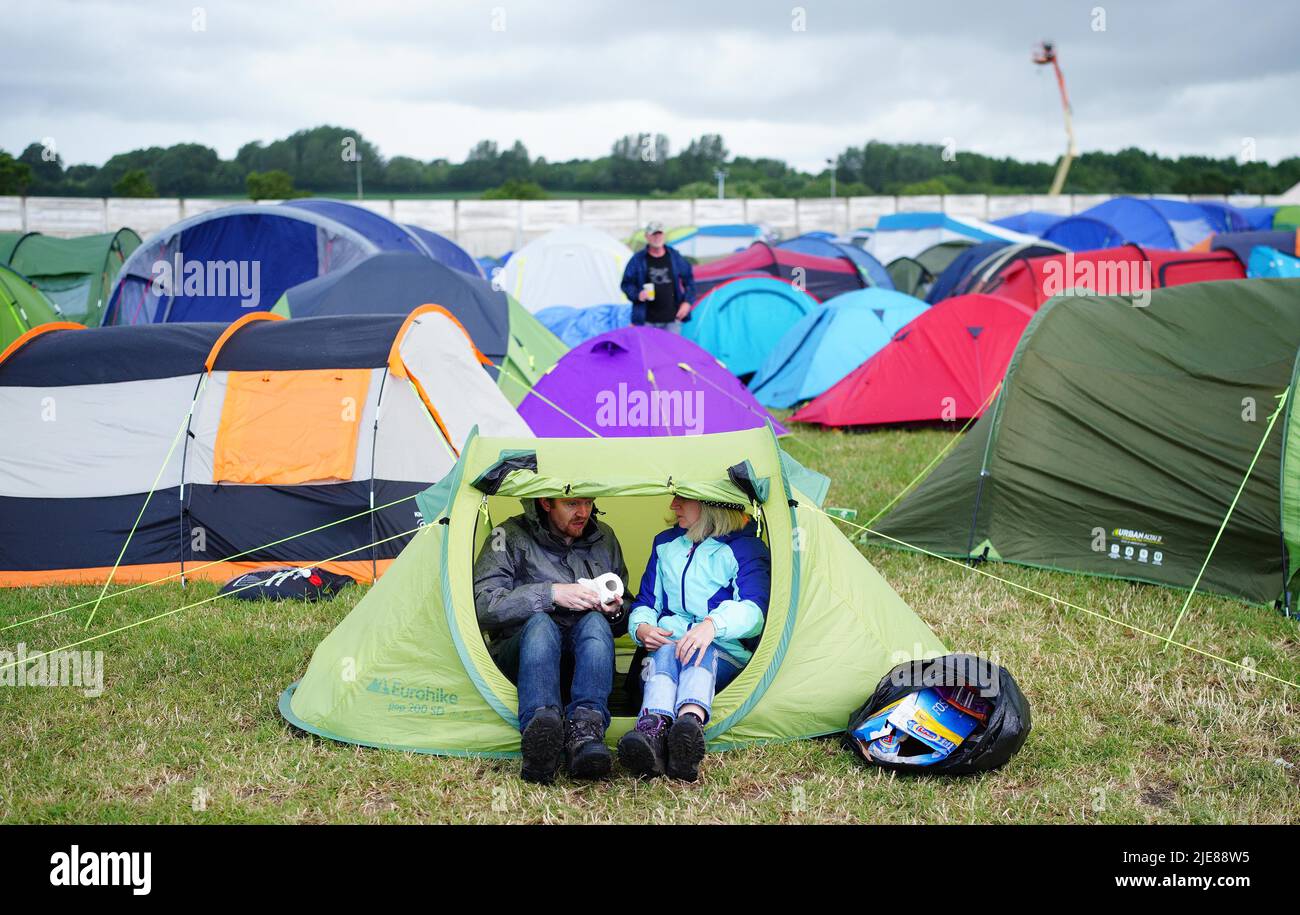 Un gardien de festival dans sa tente tenant un rouleau de toilettes pendant le Glastonbury Festival à la ferme digne dans le Somerset. Date de la photo: Dimanche 26 juin 2022. Banque D'Images