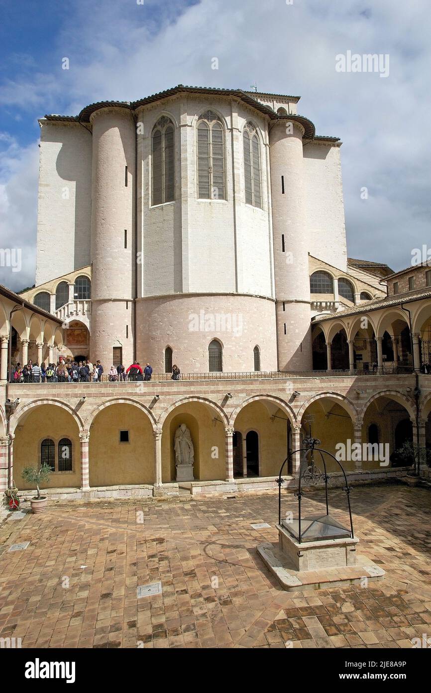 Des pèlerins et des touristes visitent le Friaire de Saint François à côté de la basilique de San Francesco d'Assise à Assise, en Italie. Il a été construit avec un rose A. Banque D'Images