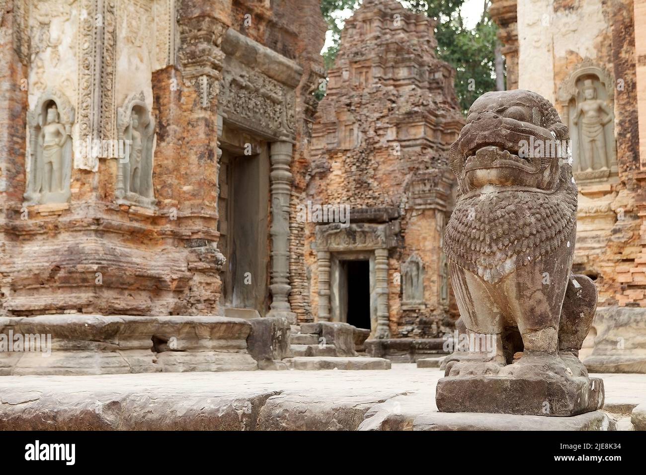 Le gardien de lion sur la plate-forme des ruines du temple de Preah Ko, Angkor, Siem Reap, Cambodge. Le temple a été construit à la fin du 9th siècle et il était le f Banque D'Images