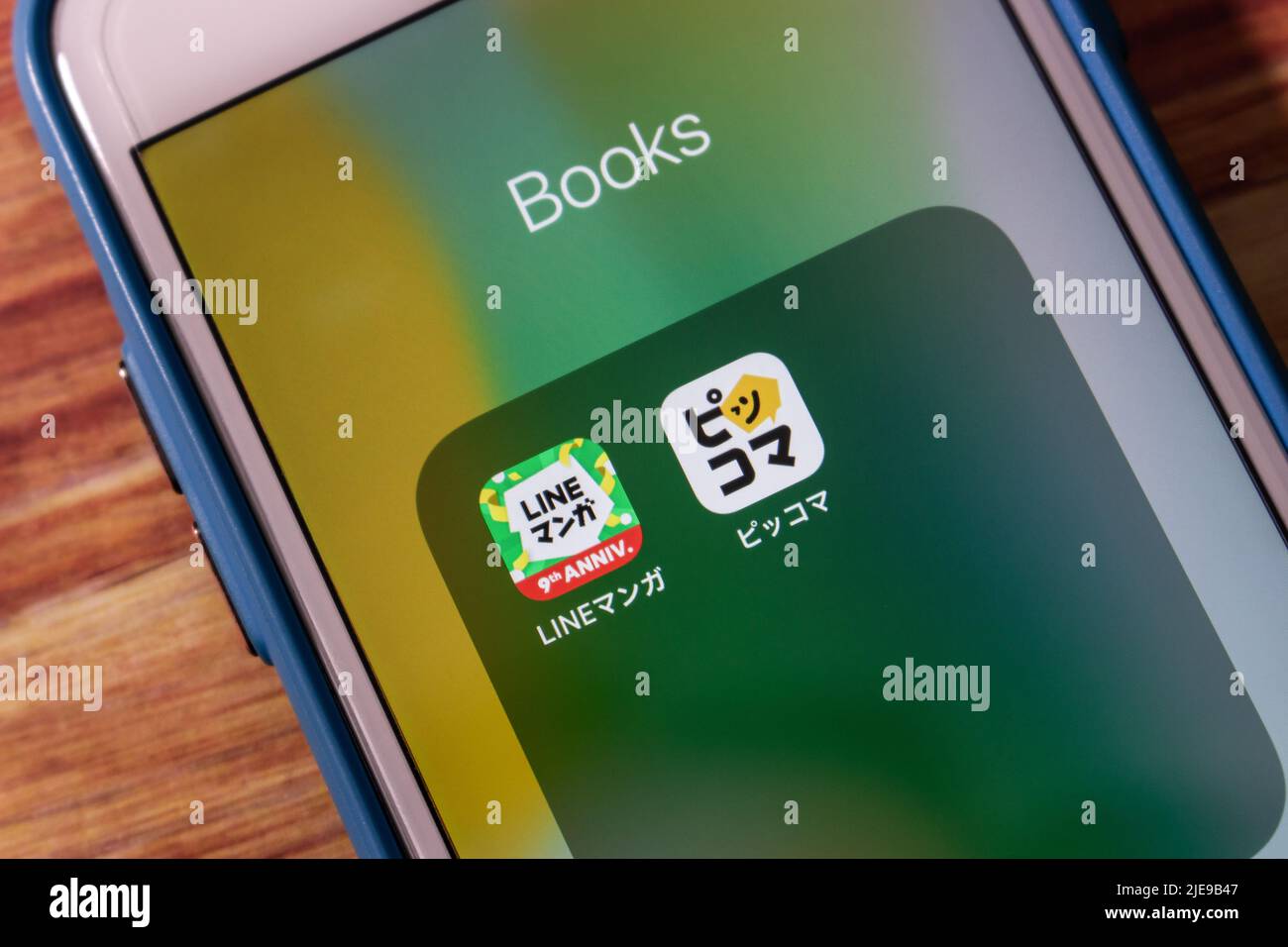Kumamoto, JAPON - juin 23 2022 : applications Piccoma et LINE Manga sur iPhone sur table en bois. Concept de service d'abonnement au manga et au webtoon en ligne japonais Banque D'Images