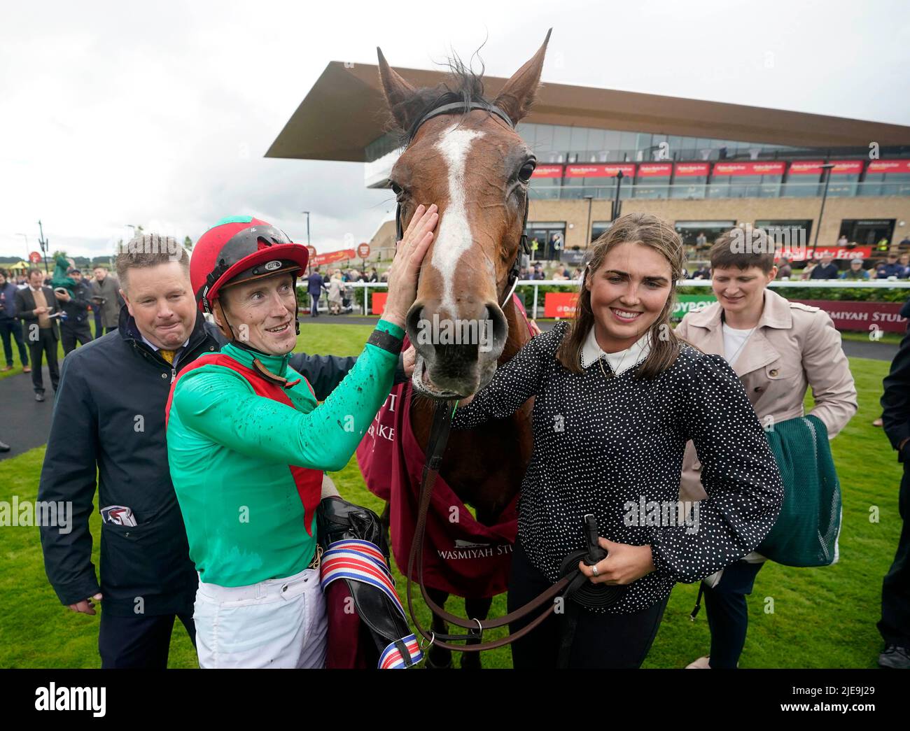 Paddy Twomey (à gauche) et William Lee (deuxième à gauche) avec la petite Coco après avoir remporté les piquets Alwasmiyah Pretty Polly lors du troisième jour du Festival du Derby irlandais sans taxe de Dubaï à l'hippodrome de Curragh dans le comté de Kildare, en Irlande. Date de la photo: Dimanche 26 juin 2022. Banque D'Images