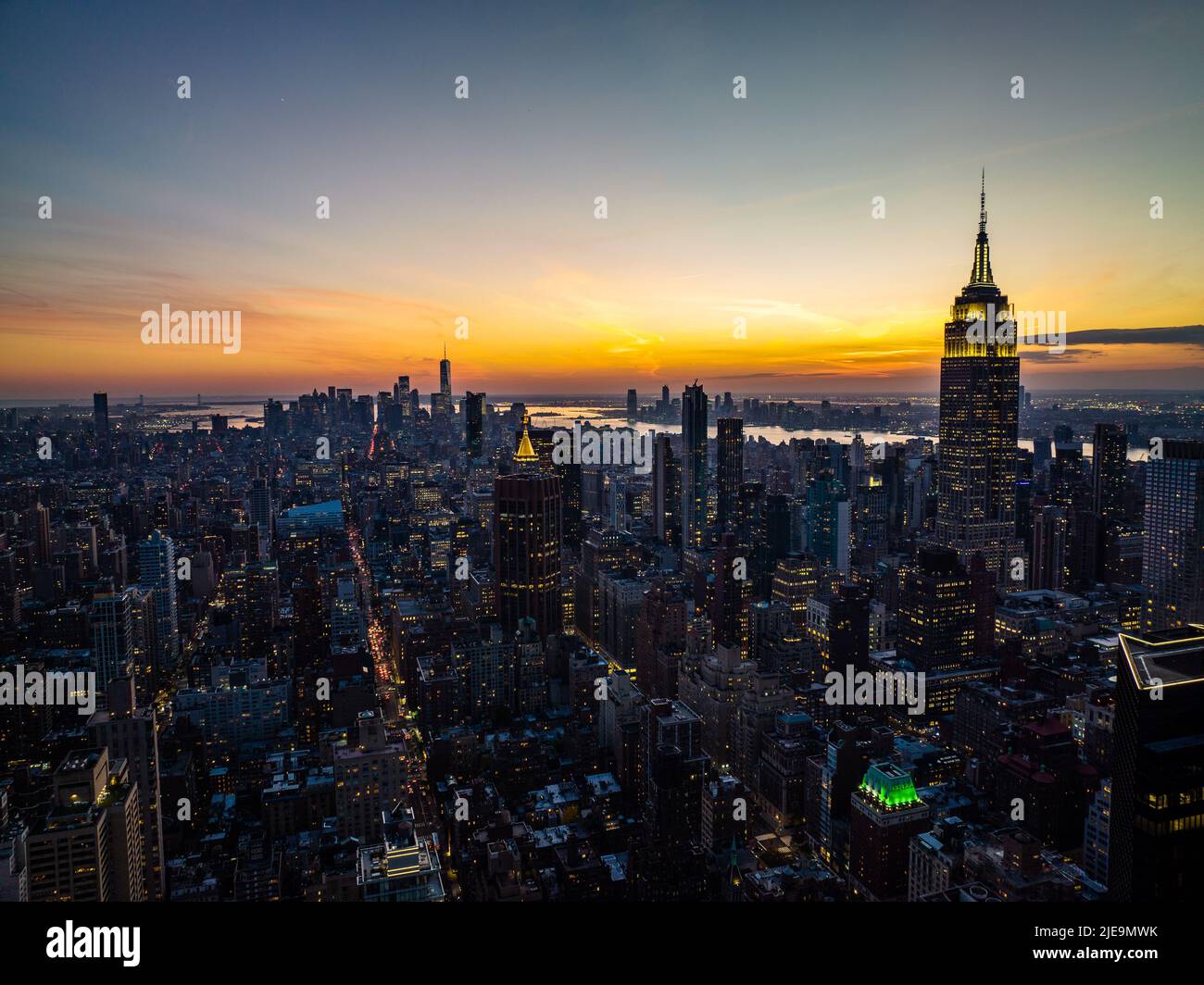 Bâtiments de haute élévation disposés dans des blocs entourés de rues. Paysage urbain et ciel de coucher de soleil coloré. Manhattan, New York, États-Unis Banque D'Images