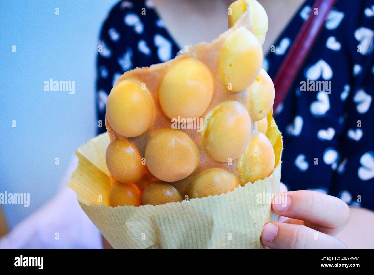 Une main tenant le Hong Kong Egg Puffs (Eggette/ gaufres) . Banque D'Images