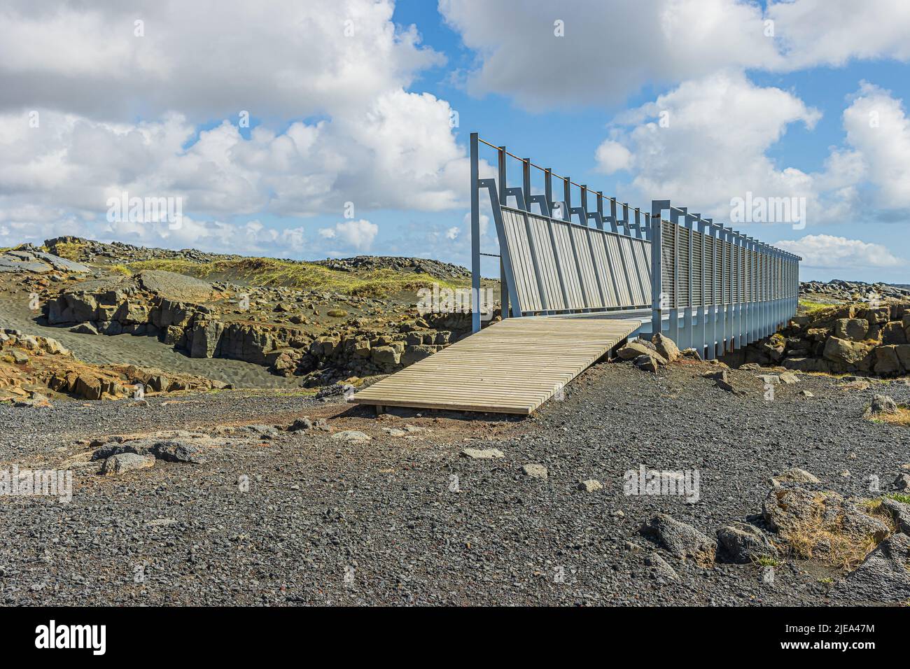 Pont en Islande sur la péninsule de Reykjanes. Le pont mène au-dessus des divisions nord-américaines et eurasiennes. La lave se trouve en arrière-plan et les nuages dans le Banque D'Images