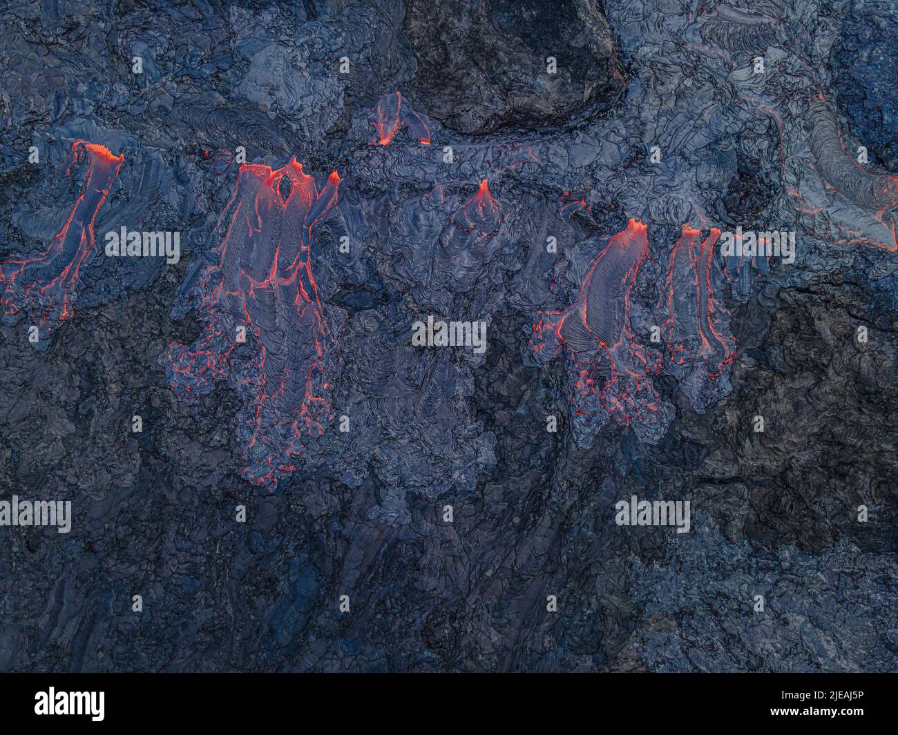 Vue d'un flux de lave actif par le dessus. Le magma chaud rouge coule d'un volcan sur la péninsule de Reykjanes en Islande. Structures dans la roche. Refroidi à l'obscurité Banque D'Images