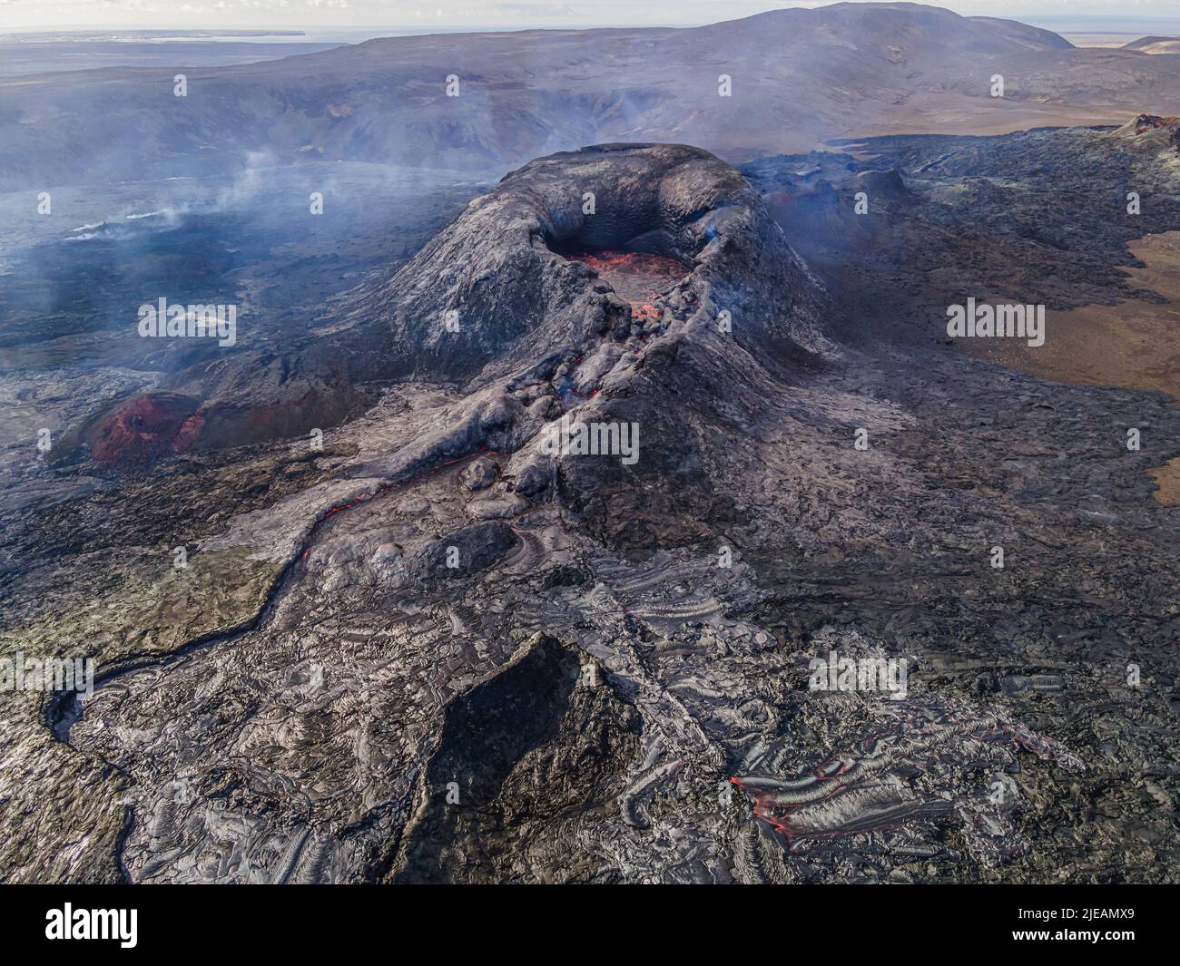 Vue sur le cratère actif avec des structures de magma rock sombre et refroidi. Paysage en Islande d'en haut. Cratères volcaniques sur la péninsule de Reykjanes. Banque D'Images