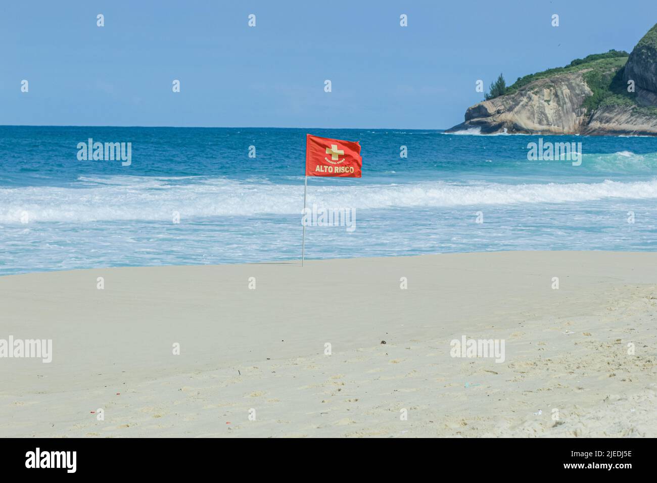 Drapeau rouge de signalisation de courant, écrit à haut risque sur une plage à Rio de Janeiro. Banque D'Images