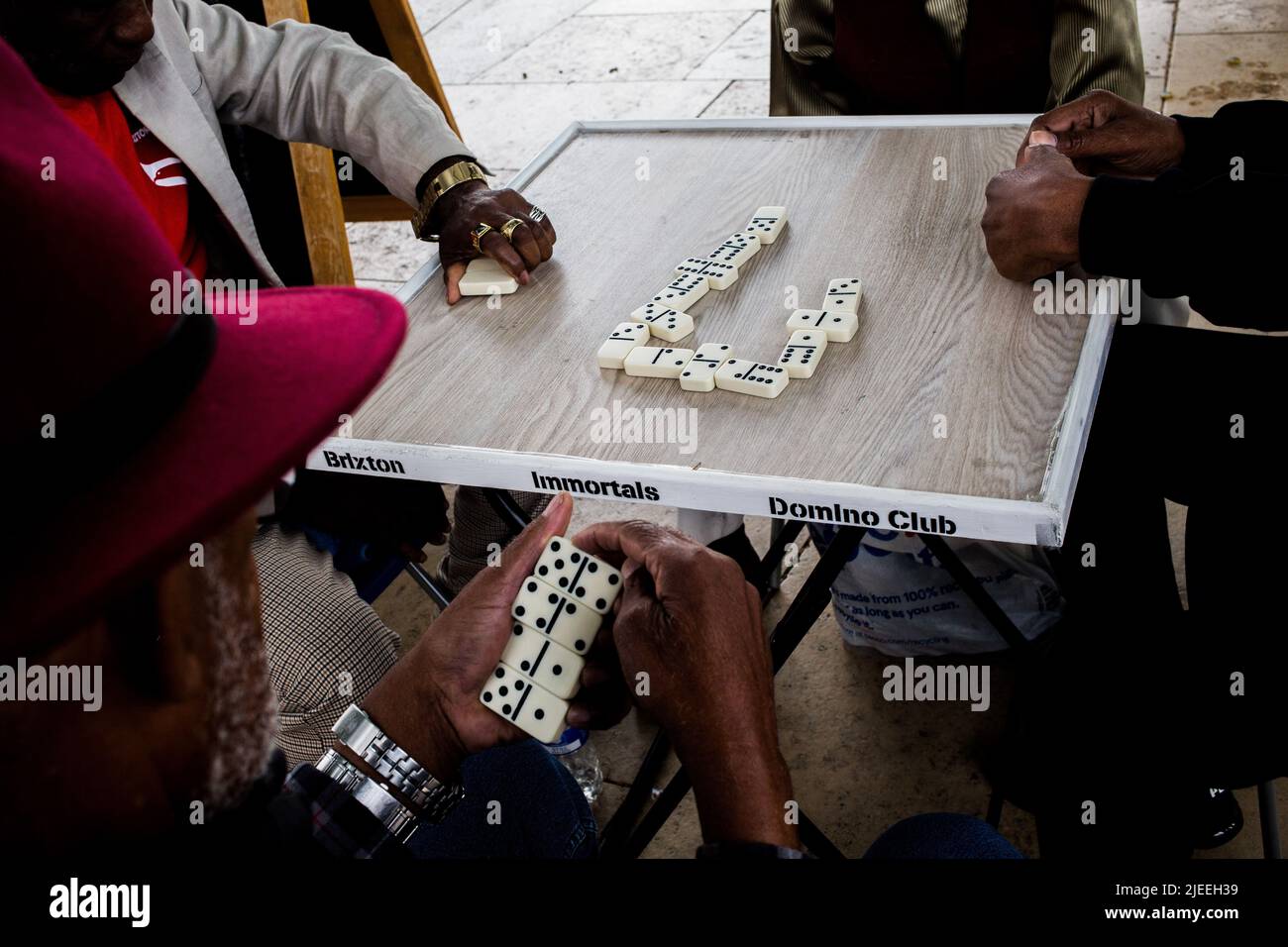 Londres, Royaume-Uni. 25th juin 2022. Les membres du club Dominos de Brixton Immortels jouent des dominos à la place Windrush à Brixton. Les générations de Windrush sont des immigrants des Caraïbes et leurs descendants qui sont venus sur les côtes de la Grande-Bretagne le 22 juin le jour où HMT Empire Windrush est arrivé aux docks de Tilbury en 1948. Crédit : SOPA Images Limited/Alamy Live News Banque D'Images