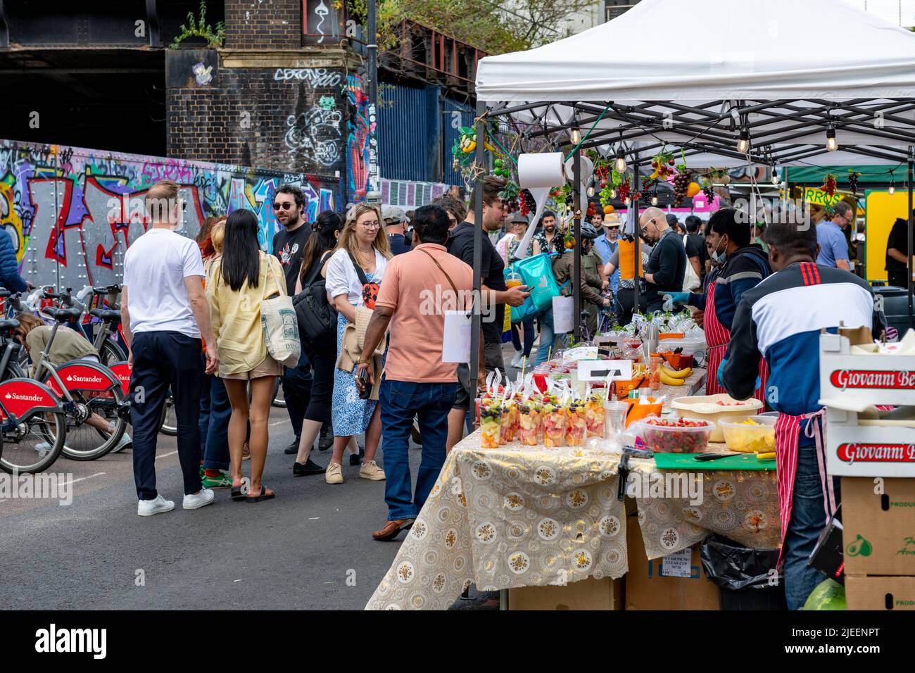 Londres. ROYAUME-UNI-06.26.2022. Une grande foule de touristes et de visiteurs dans le marché de Brick Lane visitant les stands de nourriture de rue. Banque D'Images